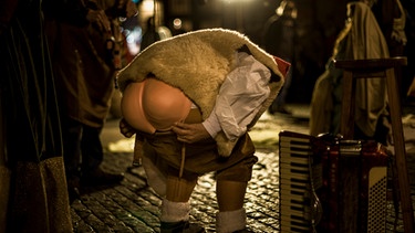Auch in einer lebendigen Krippe ist in der spanischen Stadt Barcelona ein Darsteller mit einem "Plastik-Hintern" als Caganer verkleidet. | Bild: picture alliance / ZUMAPRESS.com | Matthias Oesterle