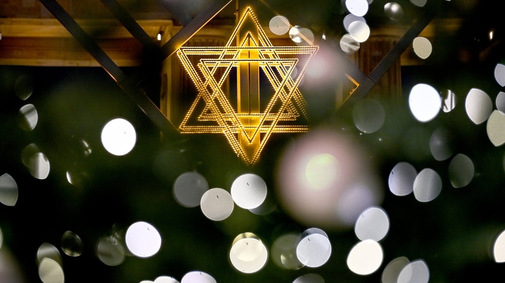 Der Stern des Chanukka-Leuchters leuchtet vor dem Brandenburger Tor zum jüdischen Lichterfest.  | Bild: dpa-Bildfunk/Britta Pedersen