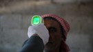 Bei einem Mann in Syrien wird Fieber gemessen. Fieber gilt als ein Anzeichen für eine Ansteckung mit Corona. | Bild: picture-alliance/dpa
