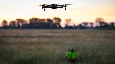 Eine Drohne mit Wärmebildkamera wird über eine Wiese im Naturpark Hoher Fläming (Potsdam-Mittelmark) gesteuert. | Bild: picture alliance/dpa | Soeren Stache