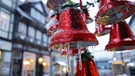 Eiszapfen hängen an einer Weihnachtsdekoration mit roten Glocken in Wernigerode im Harz. | Bild: dpa-Bildfunk/Matthias Bein