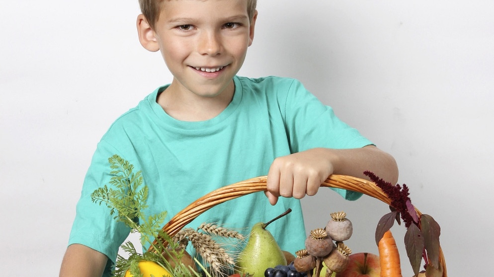 Erntedankfest: Junge mit Obst und Gemüse. | Bild: picture-alliance/dpa