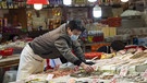 Ein Mann sortiert Fisch auf einem Markt in China. | Bild: dapa-Bildfunk/Jayne Russell 