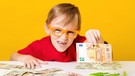 Junge mit verschiedenen Geldscheinen streckt 50-Euro-Schein in die Kamera. | Bild: colourbox.com