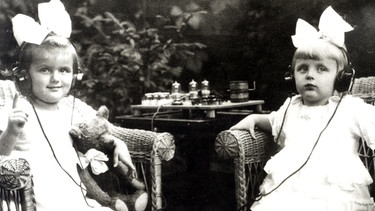 Eine schwarz-weiß-Fotografie zeigt zwei Kinder mit Kopfhörern. | Bild: BR / Historisches Archiv