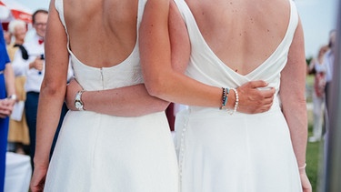 Ein weibliches Brautpaar umarmt sich. | Bild: Designerstück/Julia Müller