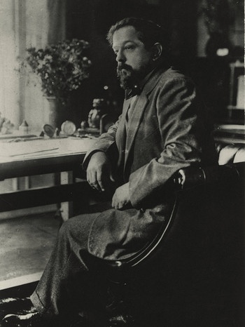 Der Komponist Claude Debussy am Schreibtisch. | Bild: picture alliance/akg-images