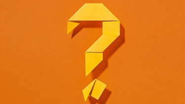 Fragezeichen, aus gelbem Papier gefaltet auf orangem Hintergrund, für "Do Re Mikro - Das Geheimnis" | Bild: colourbox.com