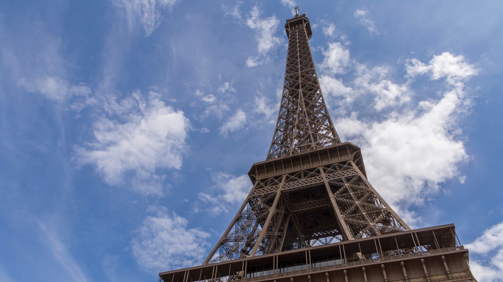 Der berühmte Pariser Eiffelturm von unten fotografiert, vor blauem Himmel. | Bild: colourbox.com