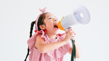 Ein Mädchen schreit in ein Megafon. | Bild: colourbox.com