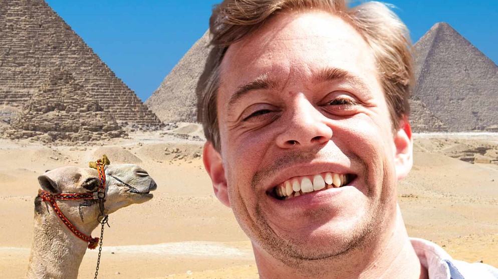 Im Vordergrund Tobi und hinter ihm ein Kamel und eine Pyramide | Bild: Megaherz