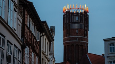 In Lüneburg in Niedersachsen wird ein 56 Meter hoher alter Wasserturm in einen "Wichernkranz" verwandelt:  Der Adventskranz ist mit einem Durchmesser von 13 Metern einer der größten Europas. | Bild: dpa-Bildfunk/Philipp Schulze