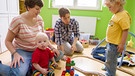 Das homosexuelle Paar Jessica und Meret Fluhr spielen im Mai 2015 mit ihren Kindern, Janusz und Seth im Kinderzimmer.  | Bild: picture-alliance/dpa