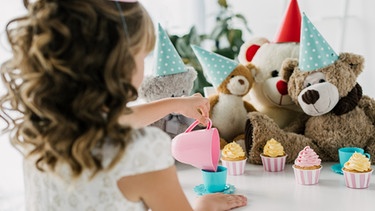 Ein kleines Mädchen feiert mit seinen Teddybären eine Party. | Bild: colourbox.com