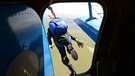 Ein Smoke Jumper - also ein Feuerwehrmann mit Fallschirm - springt aus einem Flugzeug in Russland. | Bild: picture-alliance/dpa