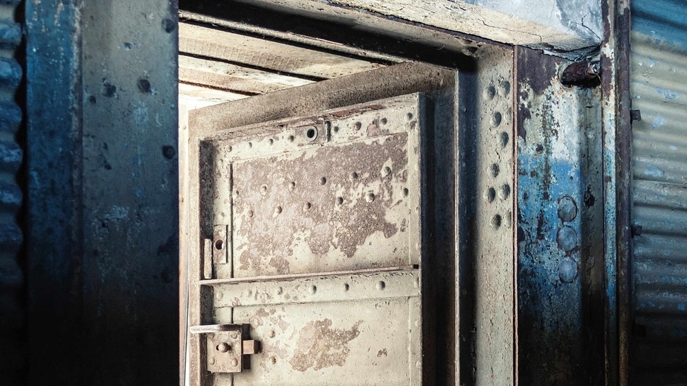 Eine schwere Eisentür mit Riegel steht offen. | Bild: colourbox.com