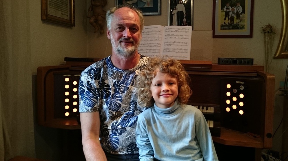 Vinzent und sein Vater sitzen zu Hause auf der Orgelbank vor der Elektroorgel. | Bild: privat
