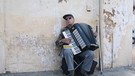 Ein blinder alter Mann spielt Akkordeon am Strassenrand, Frankreich, Languedoc-Roussillon, Saint Gilles.  | Bild: dpa-Bildfunk