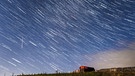 Der Sternschnuppenstrom der Perseiden. Jedes Jahr im August durchquert die Erde den Meteorstrom - und es gibt in den Nächten viele Sternschnuppen zu sehen. Das Foto ist aus 30 Fotografien zusammengesetzt, die innerhalb von 15 Minuten aufgenommen worden sind.  | Bild: picture-alliance/dpa