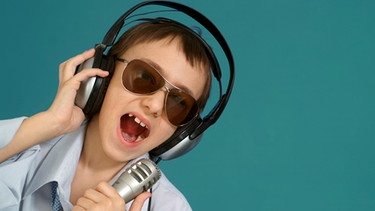 Ein Junge singt ins Mikrophon. | Bild: colourbox.com