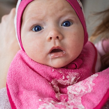 Ein Baby hat beim "Bäuerchen" Milch auf sein Lätzchen erbrochen. | Bild: colourbox.com