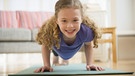 Ein Mädchen macht zu Hause Sport (Yoga). | Bild: picture-alliance/dpa