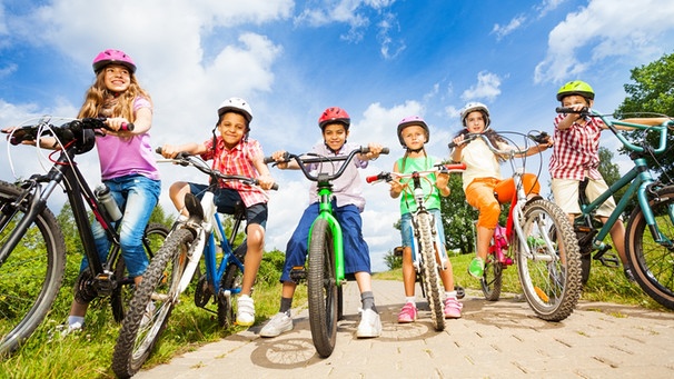 Fröhliche Kinder fahren mit ihren Fahrräder auf die Kamera zu. | Bild: colourbox.com