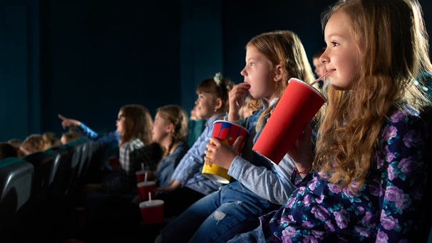 Kinder sitzen in einem abgedunkelten Kinosaal. | Bild: colourbox.com