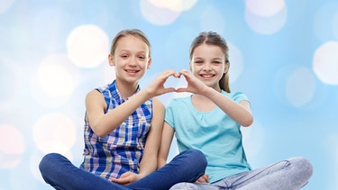 Zwei Mädchen formen gemeinsam mit ihren Händen ein Herz. | Bild: colourbox.com