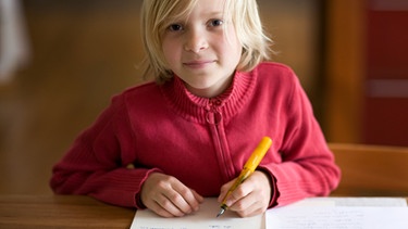 Ein Mädchen macht Hausaufgaben. Sie ist Linkshänderin. | Bild: picture alliance / photothek | Gudrun Senger