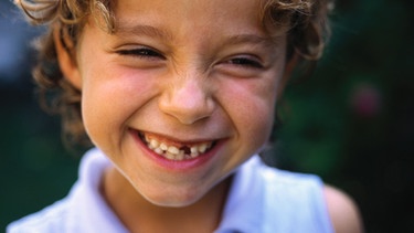 Ein Mädchen mit Zahnlücke lacht kichernd. | Bild: colourbox.com