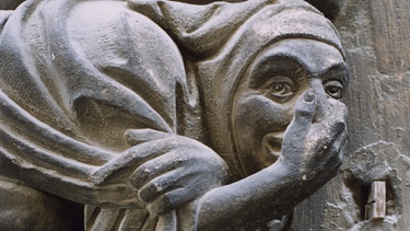 Mittelalterliche Steinfigur - so genannte Konsolfigur - hält sich die Nase zu. | Bild: picture alliance / akg-images