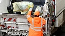 Mitarbeiter der Stadtreinigung wirft Gelbe Säcke in Müllwagen.  | Bild: picture-alliance/dpa