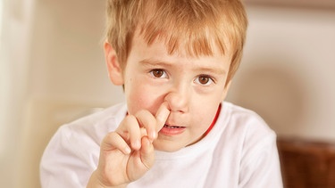 Ein Junge bohrt in der Nase. | Bild: picture-alliance/dpa