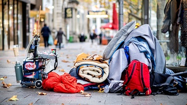 Die Habseligkeiten eines Obdachlosen liegen auf einem Bürgersteig in der Innenstadt von Hannover. | Bild: dpa-Bildfunk/Hauke-Christian Dittrich
