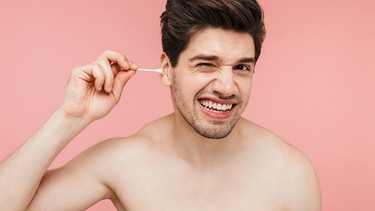 Ein Mann putzt sich mit einem Wattestäbchen die Ohren | Bild: colourbox.com