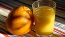 Eine Orange und ein Glas Orangensaft. | Bild: picture-alliance/dpa