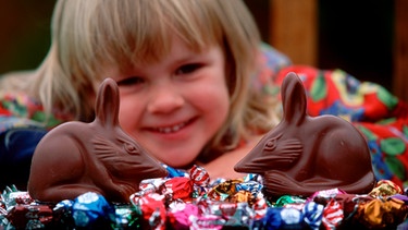 Ein Mädchen mit zwei Osterbilbies aus Schokolade. Der Kaninchenhasenbeutler dient in Australien als Ersatz für den wenig beliebten Osterhasen. | Bild: picture alliance / WILDLIFE | WILDLI/M.Harvey