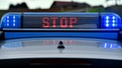 Polizeifahrzeug zeigt "Stop" an. | Bild: picture-alliance/dpa