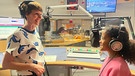 Die Radiomikro-Moderatorin Tina Gentner im Gespräch mit einem Studiokind im Bayern 2-Studio. | Bild: BR | Geli Schmaus