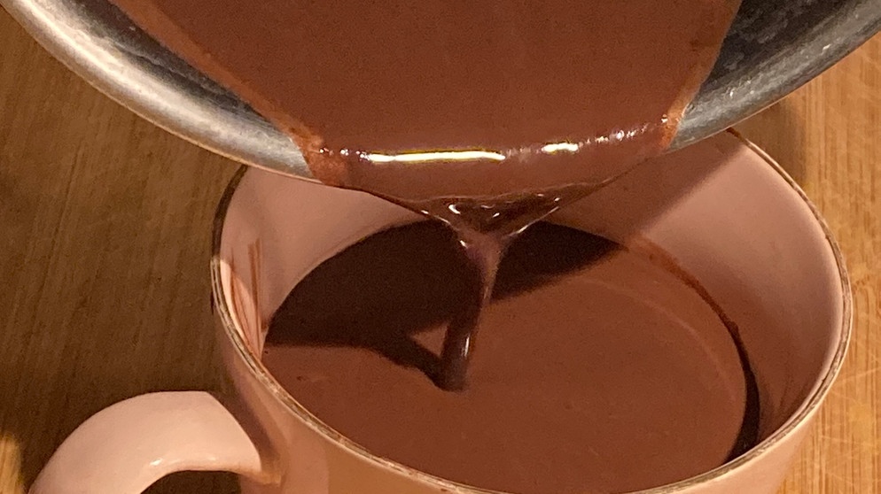 Der dickflüssige Kakao wird aus dem Topf in eine Tasse gegossen. | Bild: BR | Lilian Landesvatter