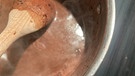 Mit dem Kochlöffel wird die Heiße Schokolade gut umgerührt. | Bild: BR | Lilian Landesvatter