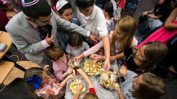 Jüdische Kinder essen in Honig eingetauchte Apfelschnitze. Ein jüdischer Brauch am Neujahrsfest Rosch Haschana. | Bild: picture alliance / AP Images | Will Vragovic