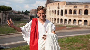 Der Römer-Check / Checker Tobi verkleidet als Senator vor dem Colosseum in Rom. | Bild: BR / megaherz GmbH