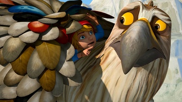 Adler im Einsatz (40) / Um Gorgo Tipss zu geben, wie man sich als Adler verhält, versteckt Nils sich unter angesteckten Federn auf Gorgos Rücken. | Bild: 2016 Studio 100 Animation/BR/Studio 100 NV