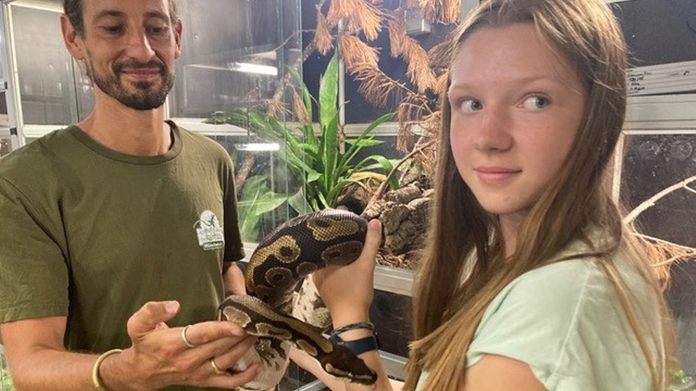 Die 13-jährige Cosima un der Tierarzt Thomas Türbl von der Reptilienauffangstation München halten eine Schlange im Arm. | Bild: BR | Geli Schmaus