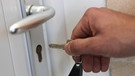 Hand mit Schlüssel vor einer Tür | Bild: colourbox.com