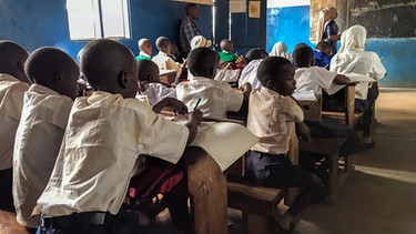 Schulkinder in Schulkleidung beim Unterricht im Klassenzimmer, inTansania, Afrika. | Bild: picture alliance / imageBROKER