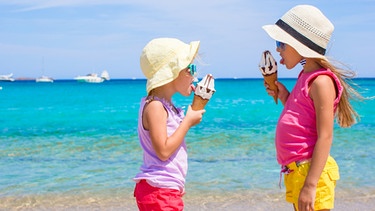 Zwei Mädchen schlecken am Strand Eis. | Bild: colourbox.com