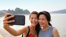 China: Zwei chinesiche Frauen machen fröhlich lachend ein Selfie an einem Strand. | Bild: colourbox.com